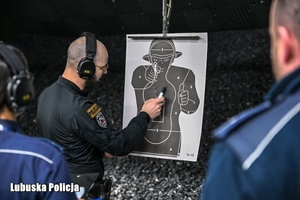 Policjant sprawdza tarczę strzelniczą.
