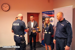 Mężczyzna wręcza zestaw kluczy policjantowi