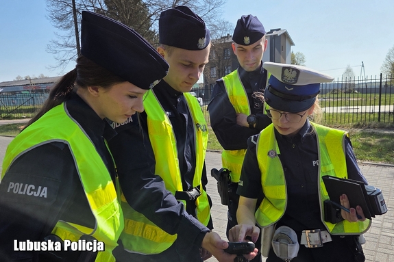 policjanci sprawdzają dane na urządzeniu