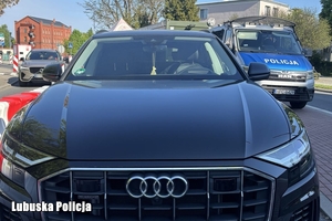 samochód Audi i radiowóz na drodze