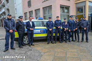 policjanci stoją przy radiowozie