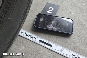uszkodzony telefon przy kole samochodu