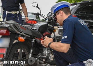 policjanci kontrolują kierującego jednośladem na drodze