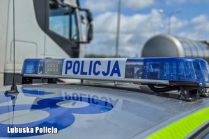 radiowóz stoi przy ciężarówkach