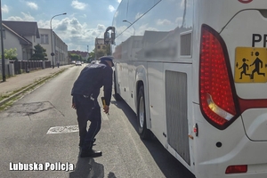policjant kontroluje stan techniczny autokaru