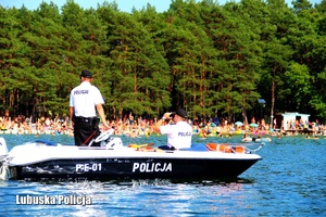 Policjanci na motorówce kontrolują bezpieczeństwo osób wypoczywających nad wodą.