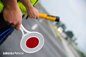 policjanci trzymają tarczkę i urządzenie kontrolne