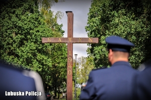 policjanci patrzą na Krzyż Katyński