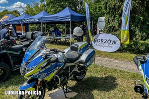 Policyjny motocykl, a w tle namioty policyjne.