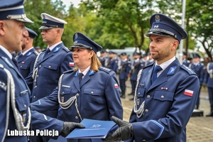 policjant odbiera gratulacje i teczkę