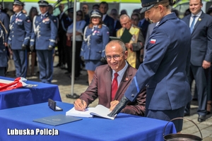 Wojewoda lubuski dokonuje wpisu w księdze pamiątkowej.