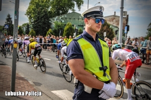 policjant zabezpiecza wyścig kolarski