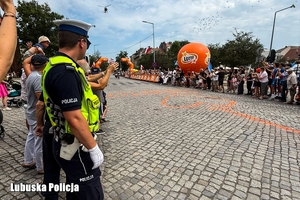 policjant zabezpiecza wyścig kolarski