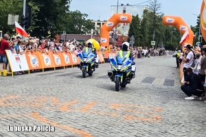 policjanci na motocyklach zabezpieczają wyścig kolarski