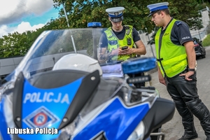 policjanci obok motocykla