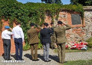Uczestnicy uroczystości oddają hołd przed pomnikiem