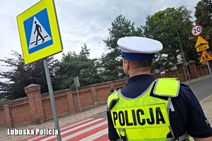 policjant sprawdza oznakowanie drogi