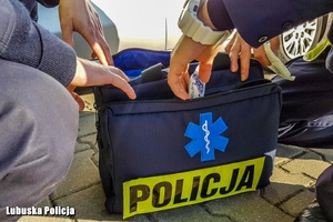 policjanci sięgają do torby medycznej