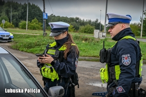 Policjanci podczas przeprowadzania kontroli drogowej.