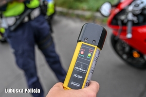 Urządzenie do badania stanu trzeźwości kierujących w dłoni policjanta.
