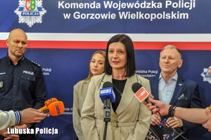 Kobieta przed mikrofonami na konferencji