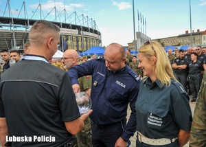 Policjant losuje kolejność drużyn podczas zbiórki krwi.