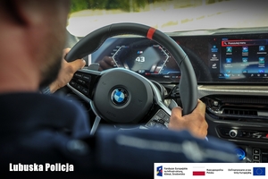 Policjant podczas kierowania radiowozem - zdjęcie z wnętrza.