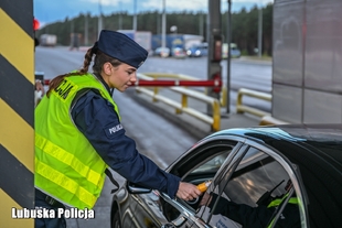 Policjant sprawdza trzeźwość kierującego pojazdem na autostradzie.