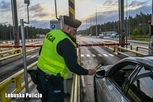 Policjant sprawdza trzeźwość kierującego pojazdem na autostradzie.