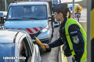 Policjant sprawdza trzeźwość kierującego pojazdem na autostradzie.