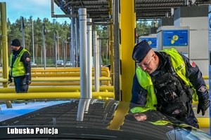 Policjant sprawdza trzeźwość kierującego pojazdem na autostradzie.
