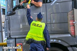 Policjant sprawdza trzeźwość kierującego pojazdem na autostradzie.