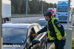 Policjantka sprawdza trzeźwość kierującego pojazdem na autostradzie.