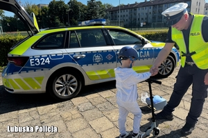 policjant wręcza kask osobie